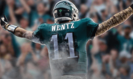 Back shot of Carson Wentz in an Eagles uniform with his arms stretched out, celebrating a touchdown.