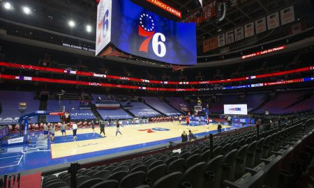 The basketball court at Wells Fargo Center with the huge scoreboard showing the 76ers logo.
