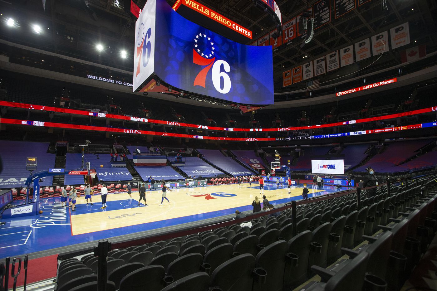 The basketball court at Wells Fargo Center with the huge scoreboard showing the 76ers logo.